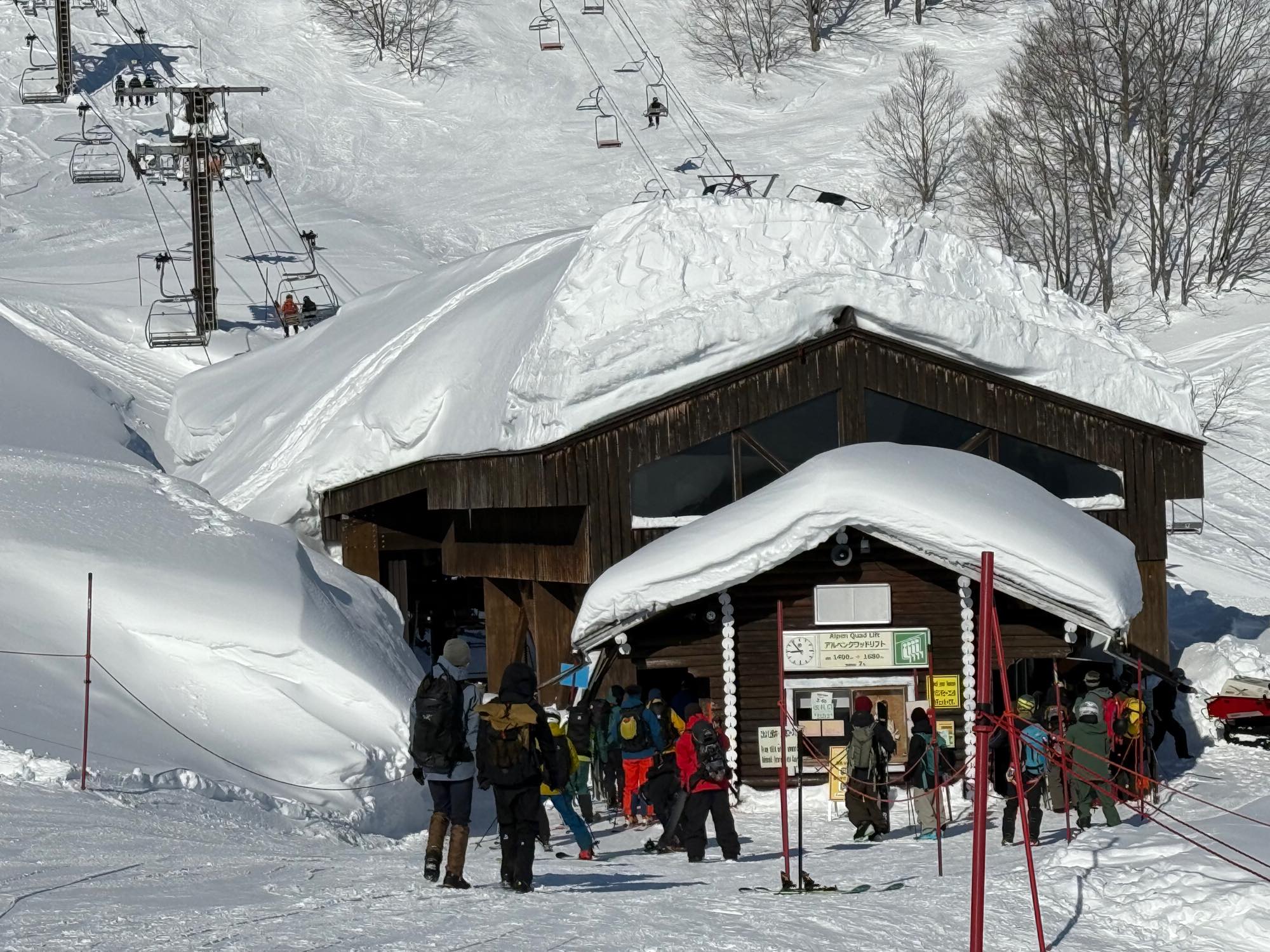 雪に覆われたリフト乗り場へ向かうスキーヤーたち