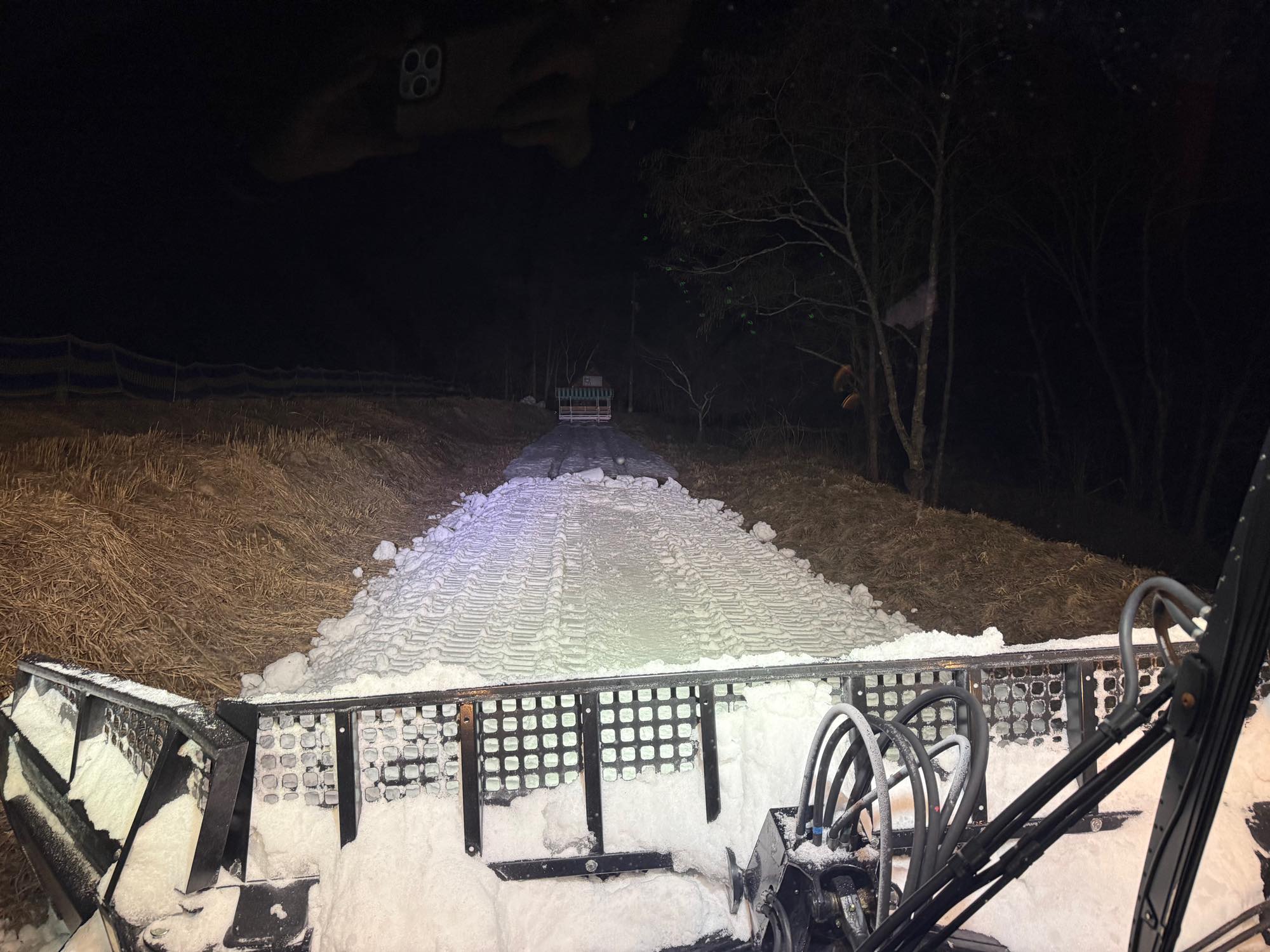 圧雪車から見た、地面の見える斜面に雪をつないでいる作業