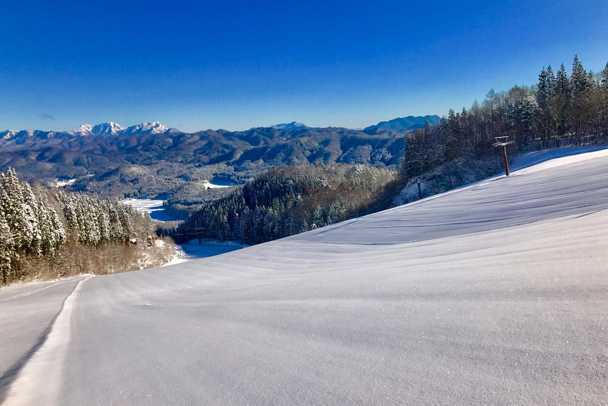 雪が積もったスキーコースと山々