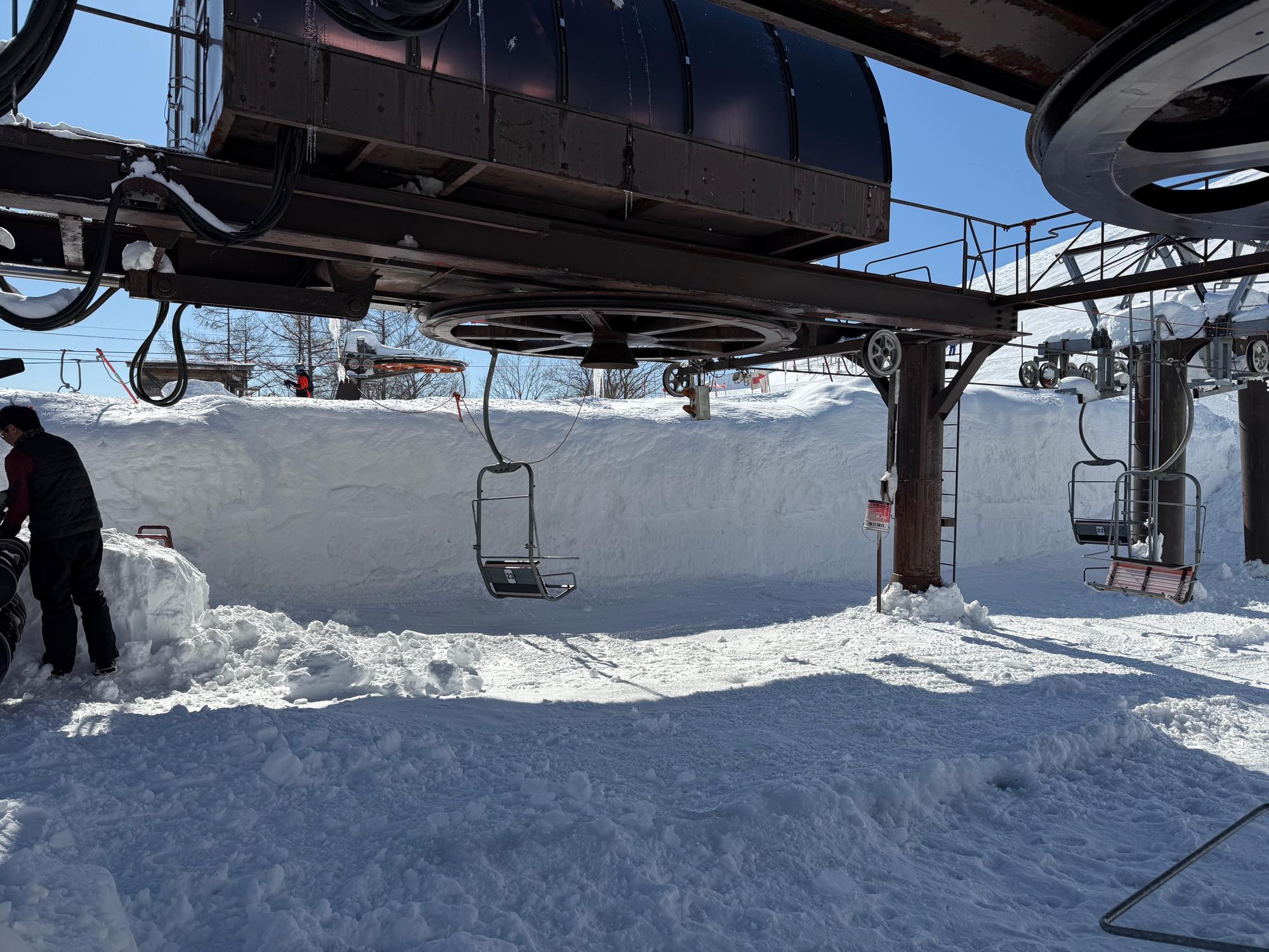 雪が積もったリフト乗り場と設備の近くにいる人