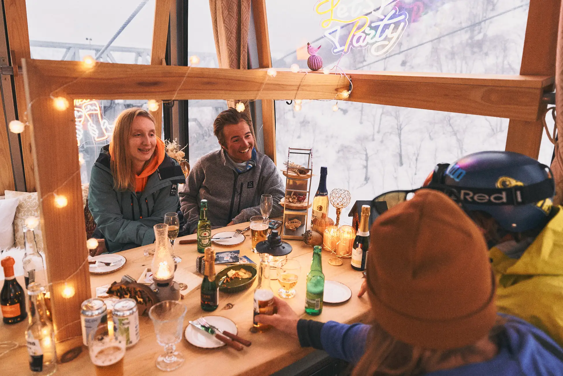 雪景色が見える貸切ゴンドラ内で飲食を楽しむ参加者