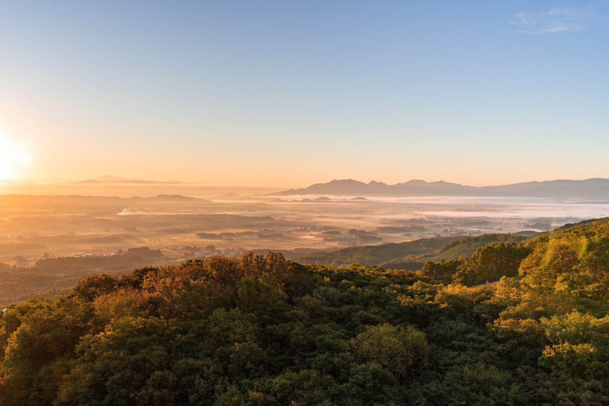 朝日に照らされ、雲海が広がる雫石盆地と山々